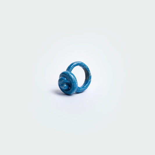 Anillo en fondo blanco hecho a mano en forma de merengue y en material de cerámica azul