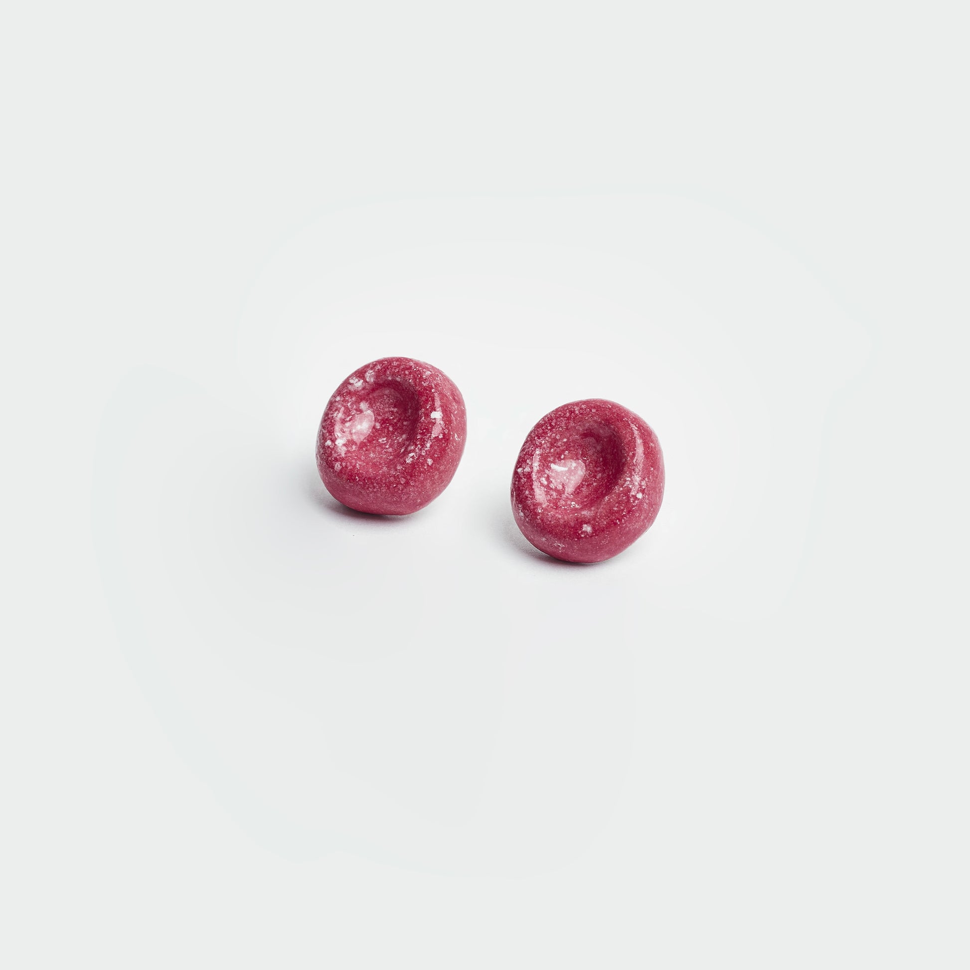 Aretes estilo topo en fondo blanco en material de cerámica y en color rojo